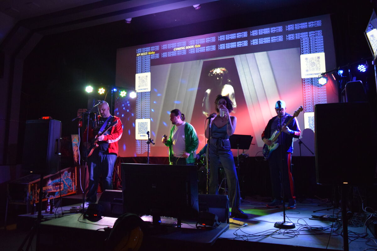 Lead Singer Wanted full stage production with band, singer, projected music video, QR codes, and stage lighting
